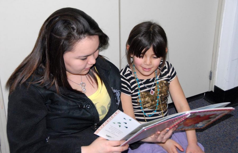 GILA sophomore Regina Harry reads a book to Galena elementary student Lily Esmailka.