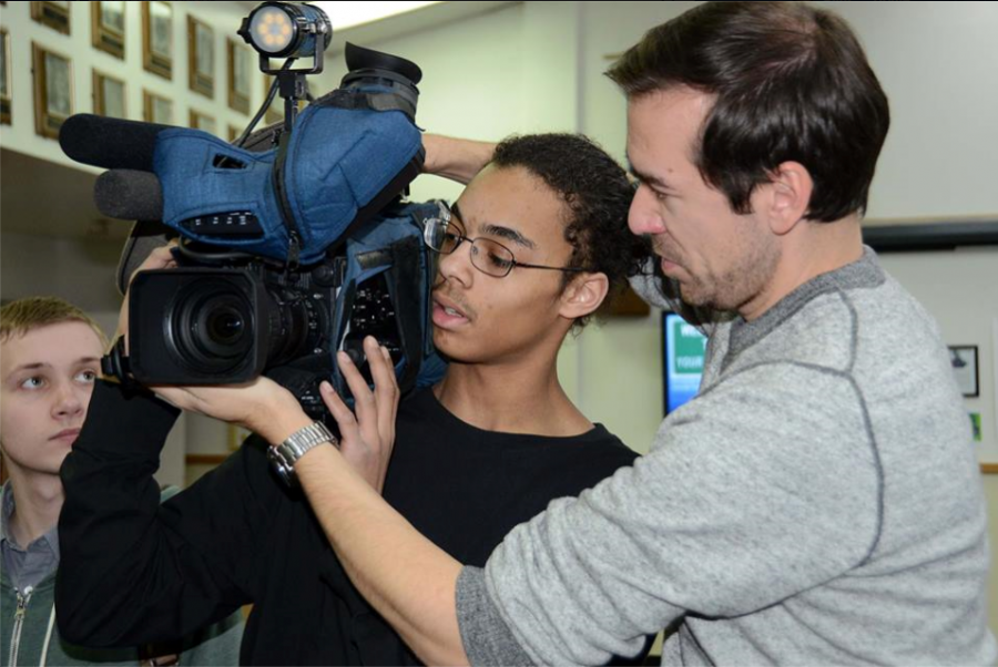 KTUU Dan Carpenter shows aspiring videographer how to operate the kind of camera used to record the evening news.